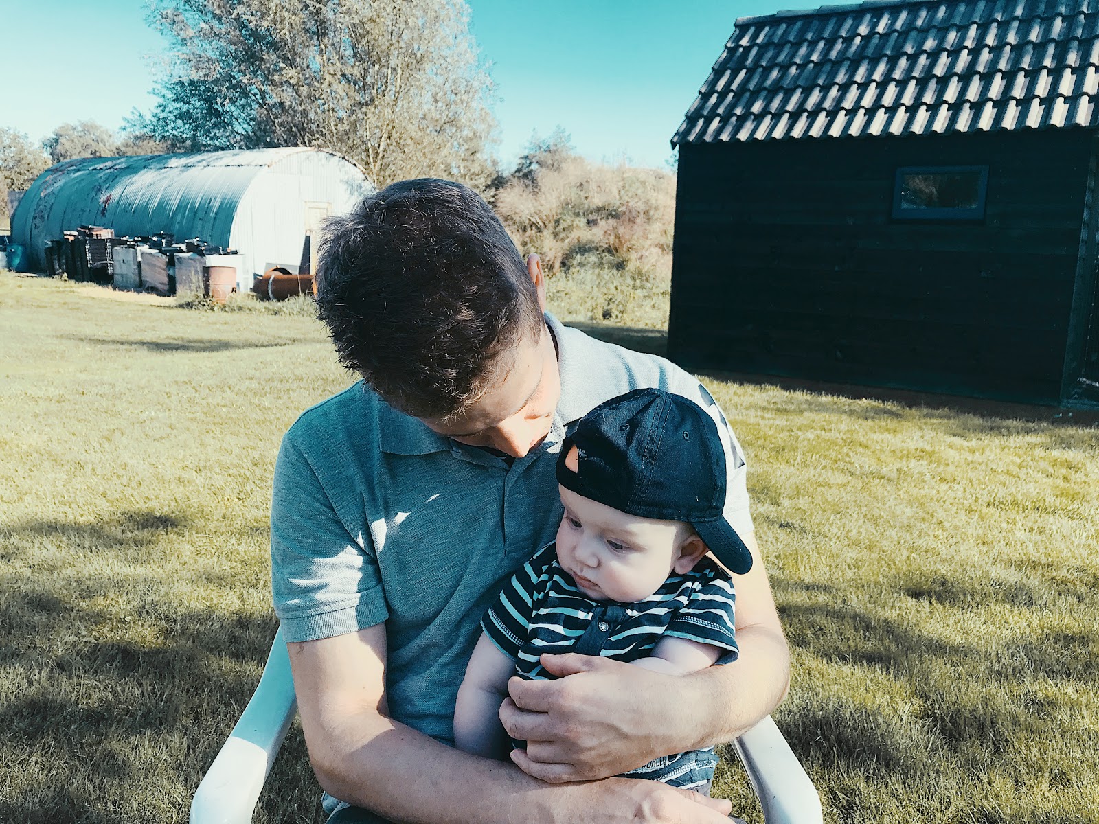 Julius is 6 maand oud. Bij papa op schoot buiten op de stoel. 