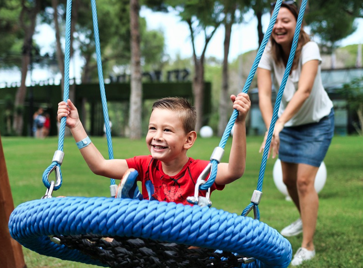 Kom tot rust op één van de leukste vakantieparken in Limburg. Vakantie park de Leistert in Roggel. Kind zit op een schommel en mama duwt hem de lucht in.