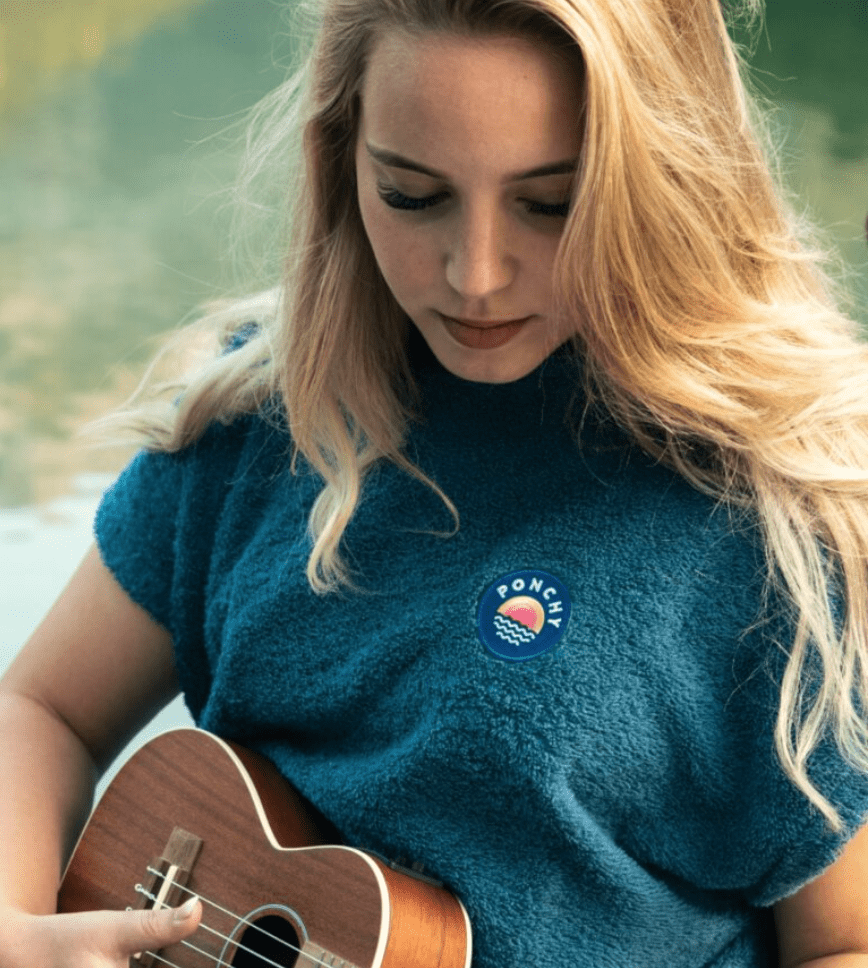 vrouw met gitaar en ponchy aan