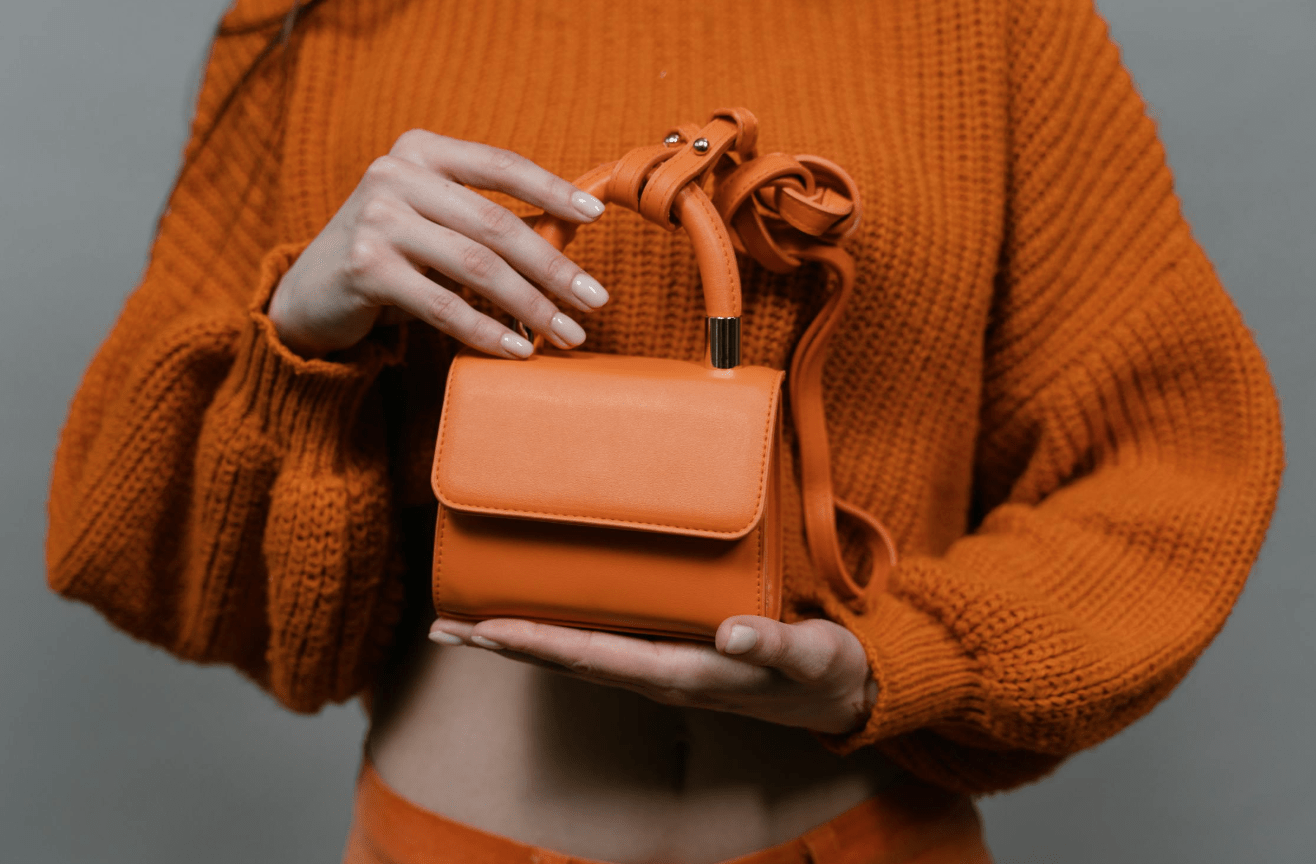 vrouw met oranje mini bag - trend tassen 2022